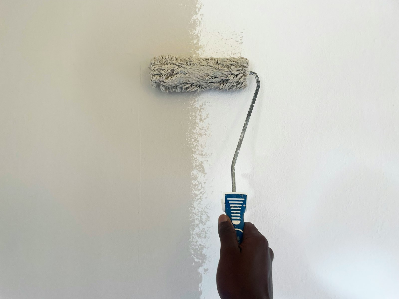 Painter rolling a clean coat of paint onto a wall